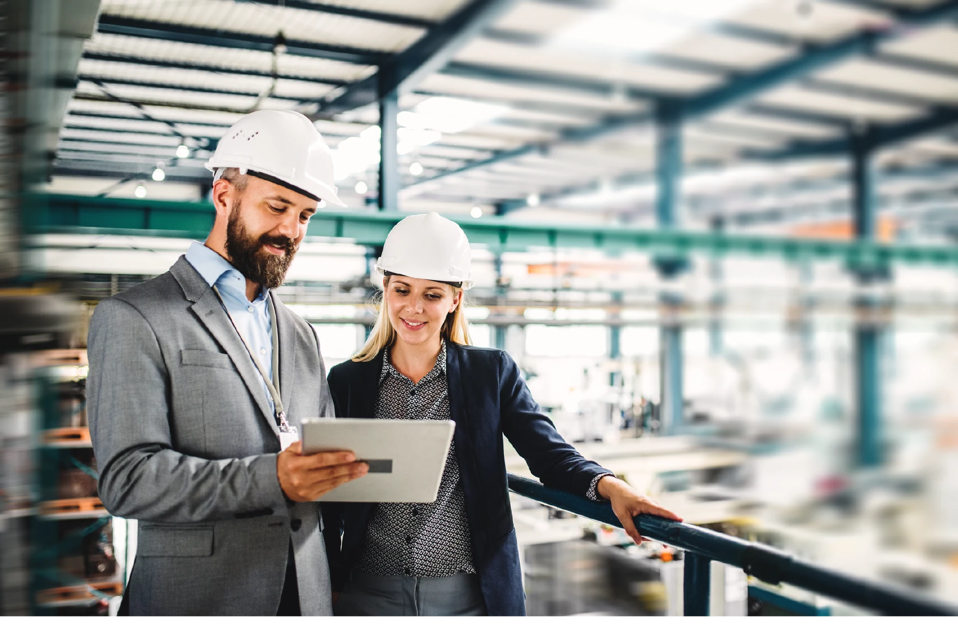 Two professionals discussing on a tablet in a manufacturing facility
