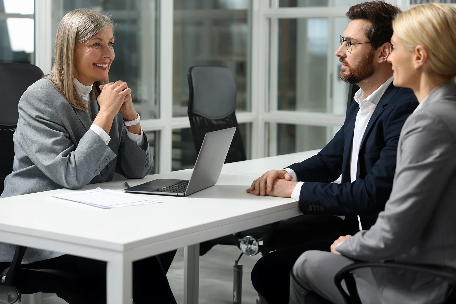 Business meeting between three professionals discussing loan automation.