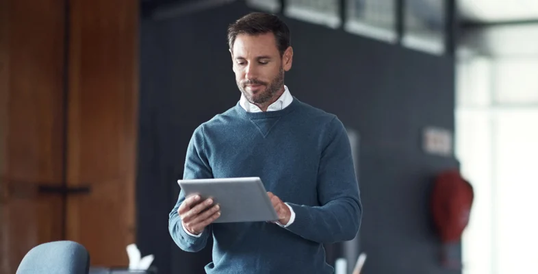 Corporate professional holding digital tablet inside modern office setting