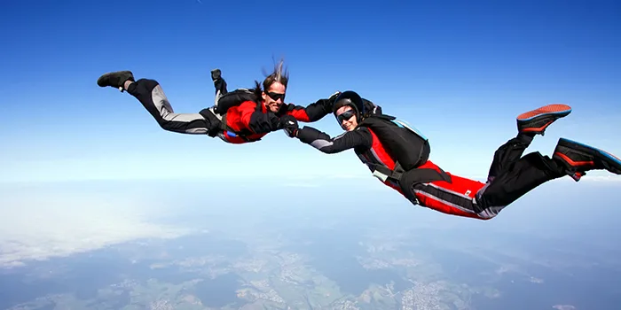 Two skydivers performing freefall formation jump for Pegasystems partnership