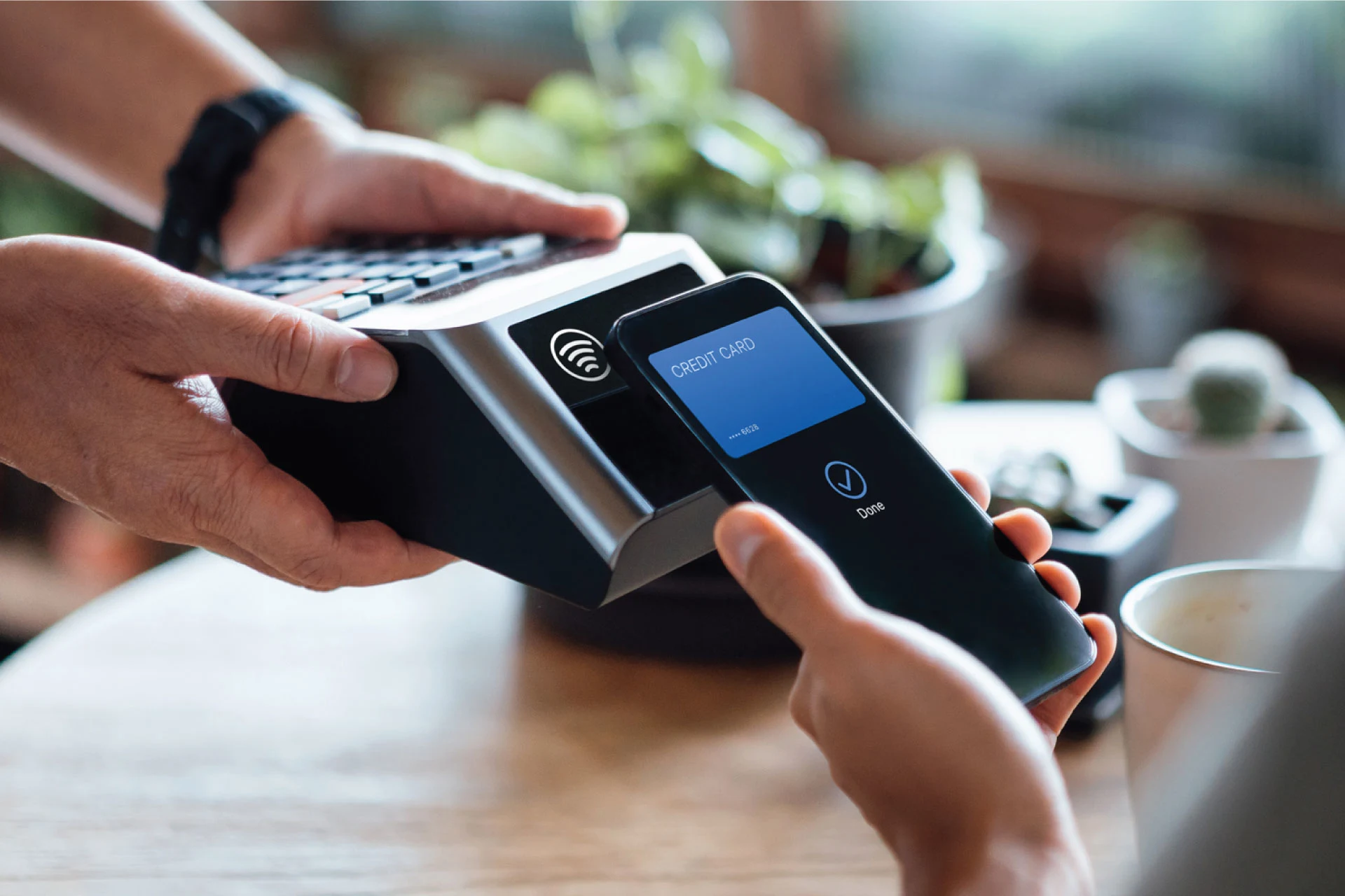 Person using a mobile phone for contactless payment at a retail location.