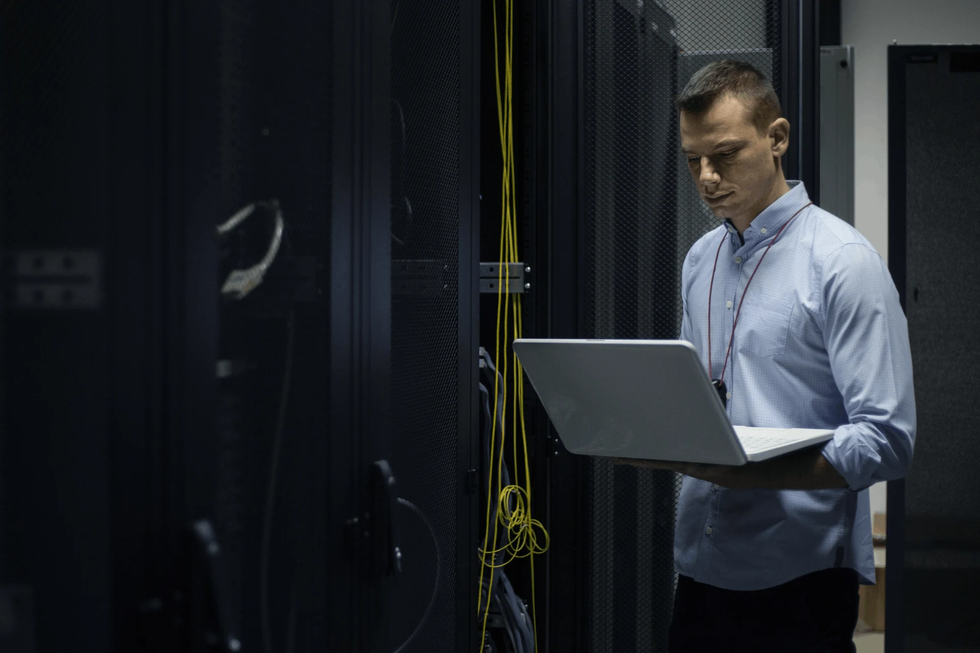 Professional using a laptop in a data center during a security assessment.