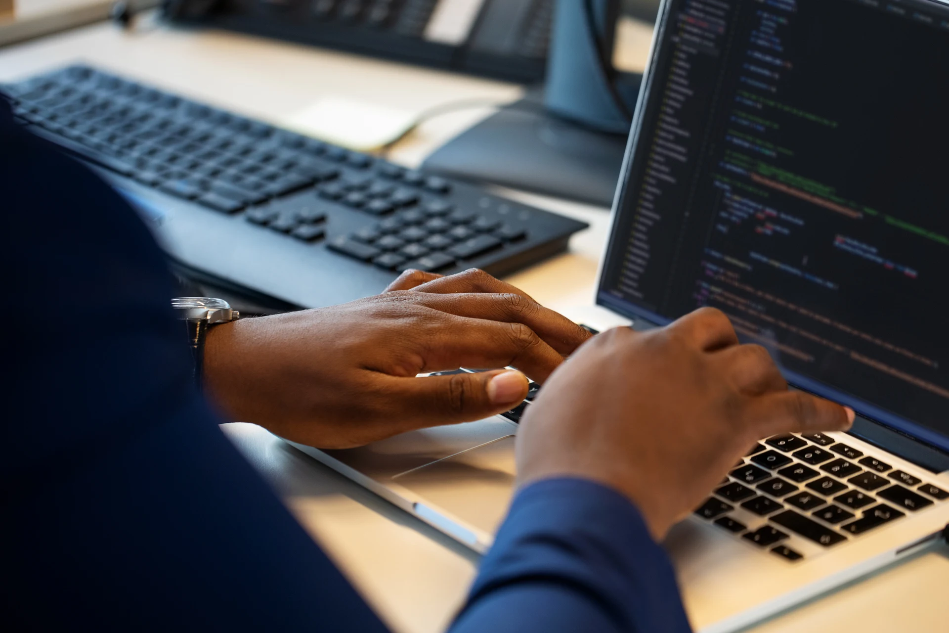 Developer typing on a laptop during testing for hi-tech applications