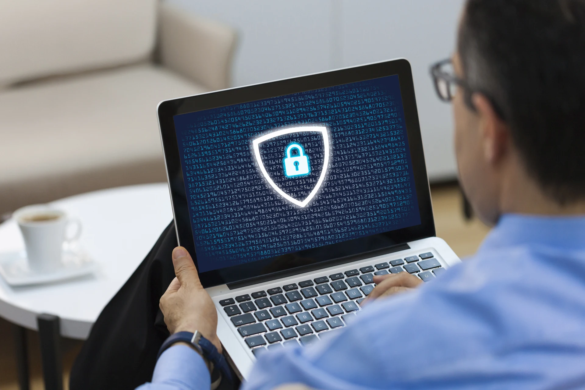 Person using a laptop displaying a digital security shield on screen