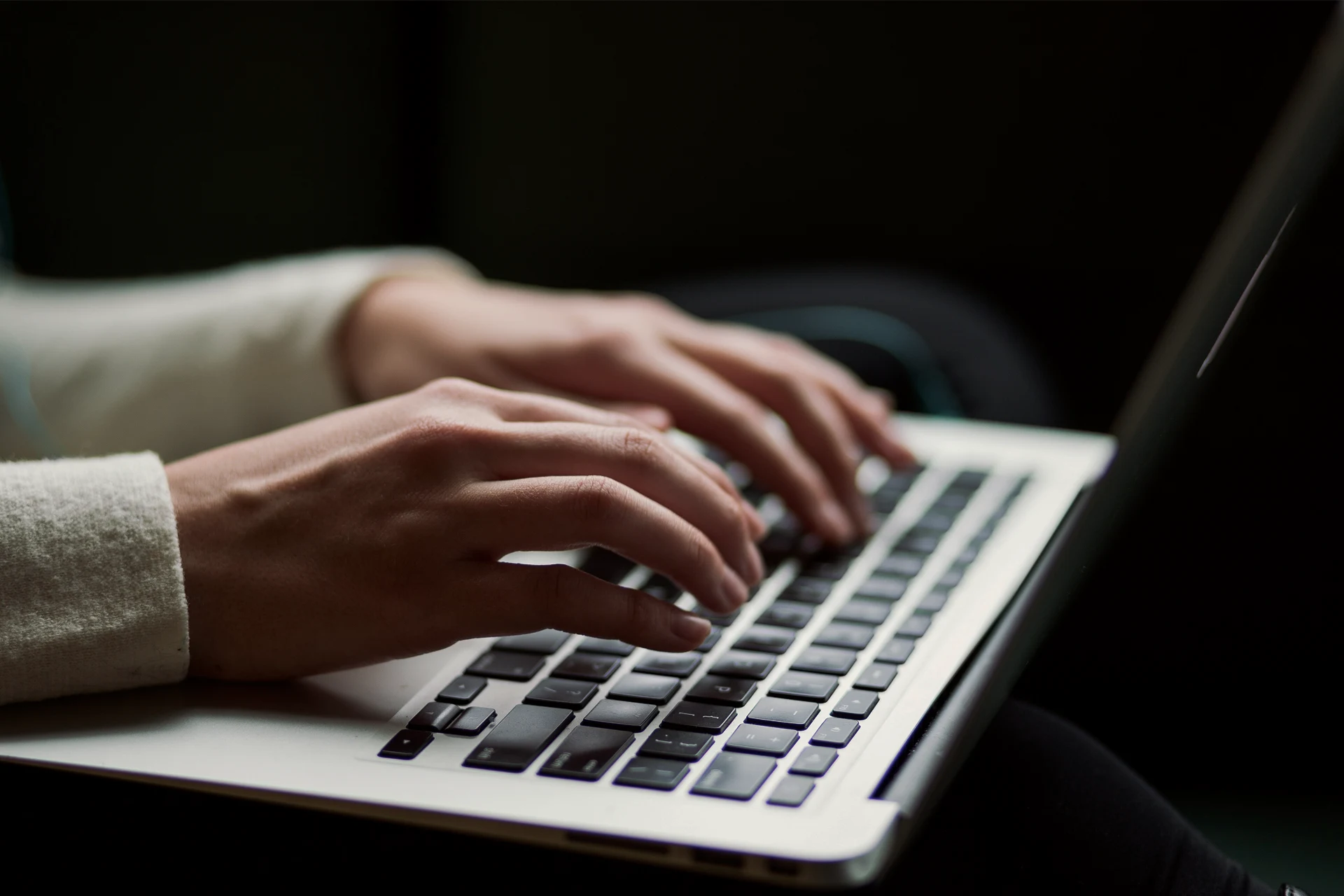 Hands typing on a laptop, related to cybersecurity and finance topic.