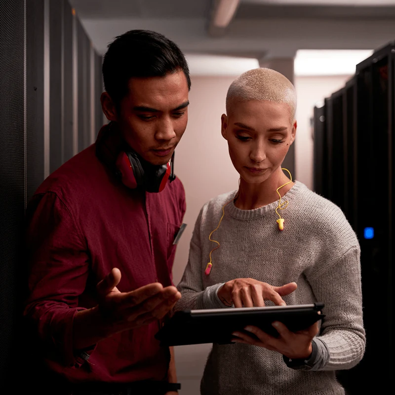 Two professionals discussing Oracle Cloud applications in a data center.