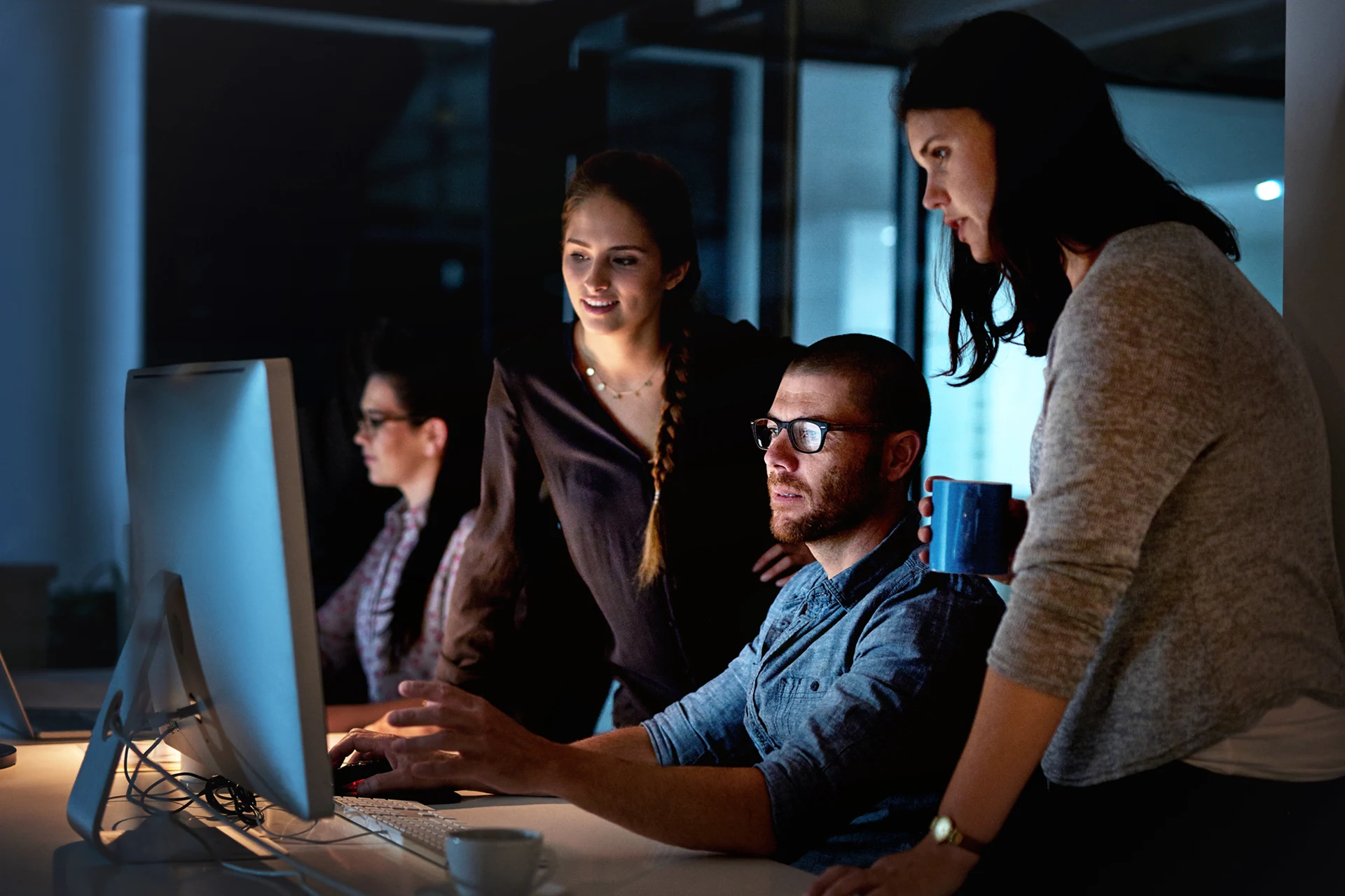 Team collaborating on a computer, discussing digital assurance strategies