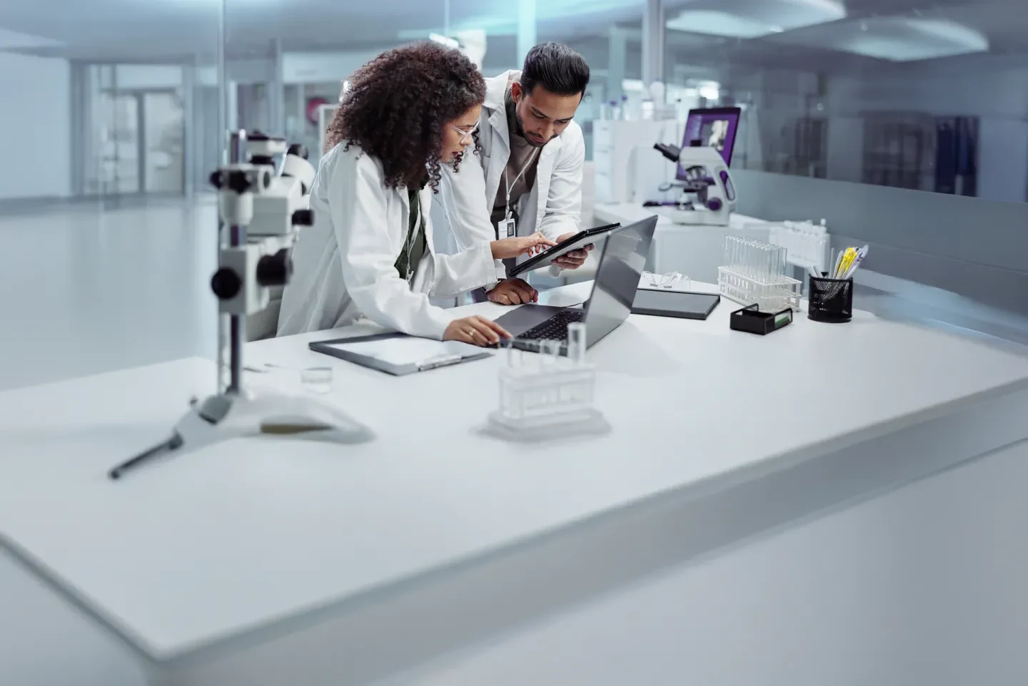 Researchers collaborating on a laptop in a laboratory setting