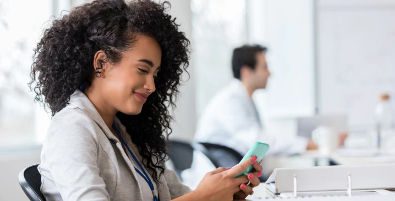 Professional using smartphone inside modern human digital employee experience office