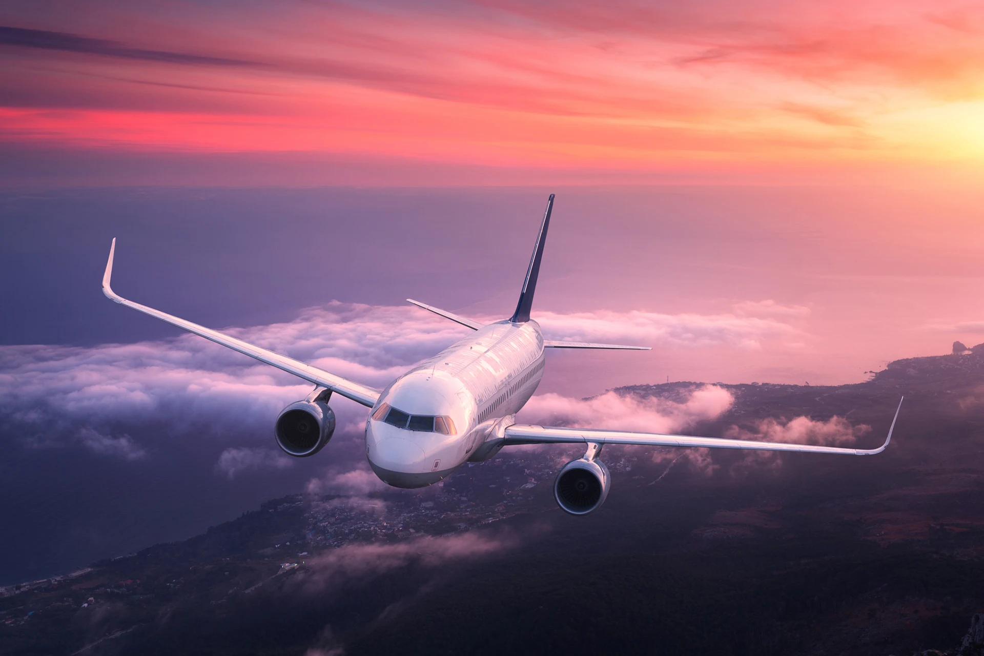 Passenger aircraft flying above clouds during sunset for aerospace client