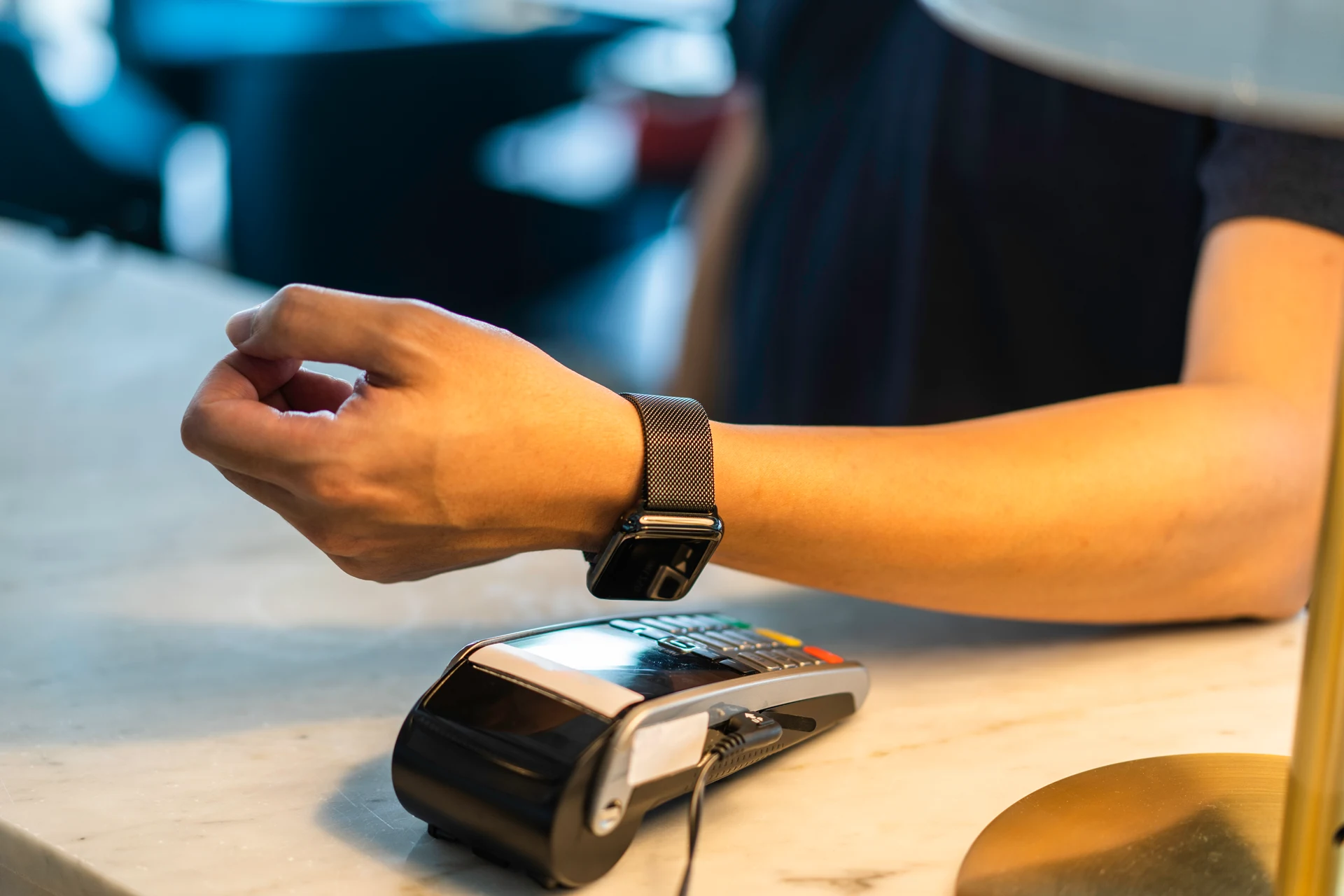 Hand using a smartwatch to make a payment at a point-of-sale terminal