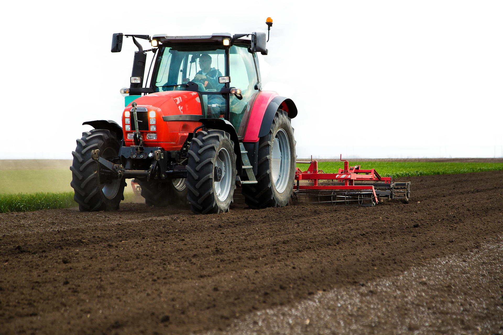 Tractor preparing soil for planting in an agricultural field