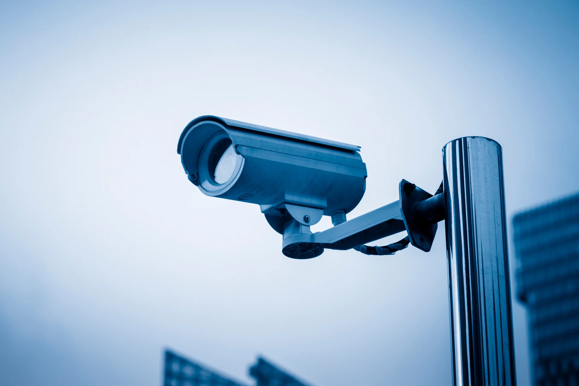 Surveillance camera mounted on a pole in an urban environment.