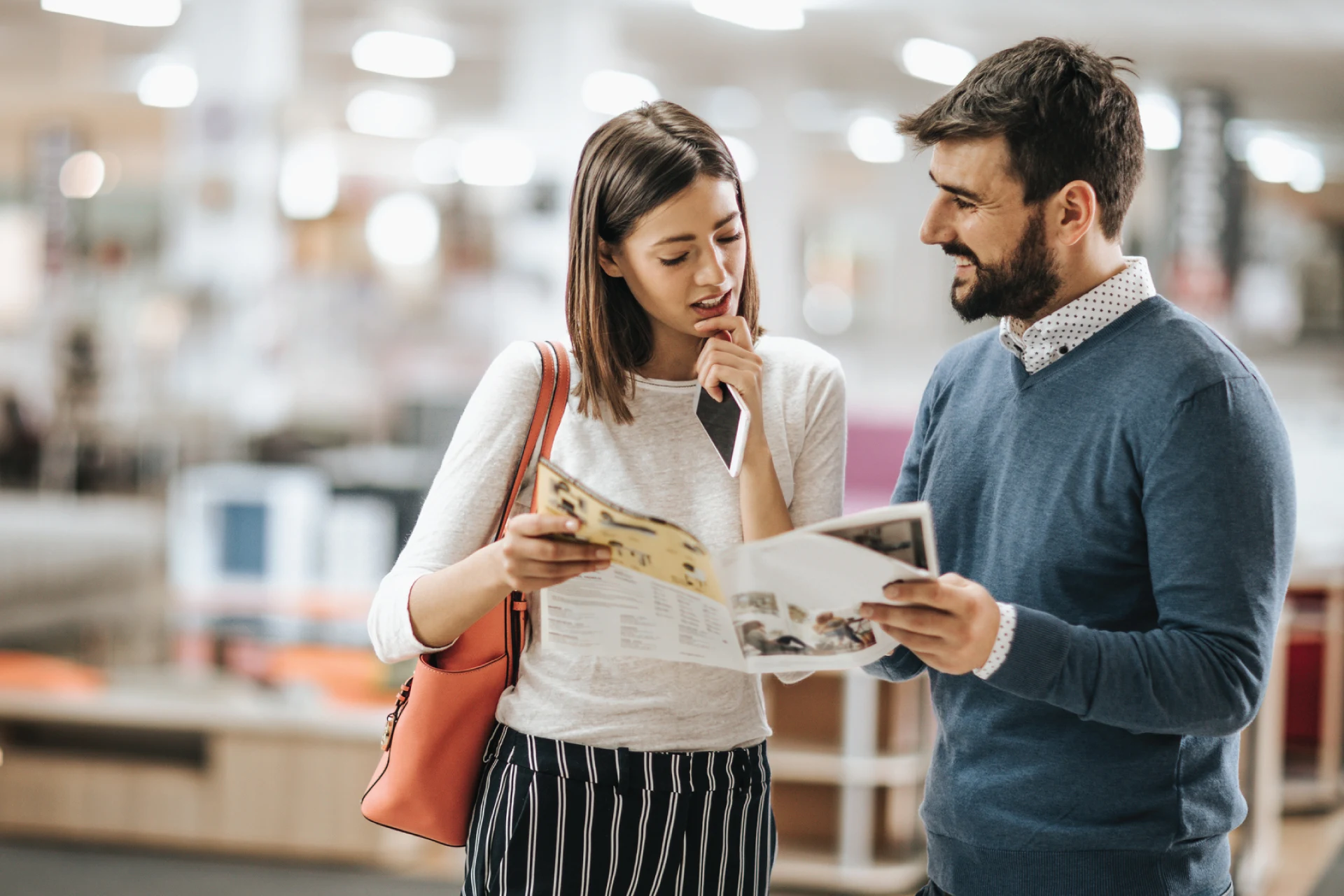Two individuals reviewing a brochure in a home furnishings store