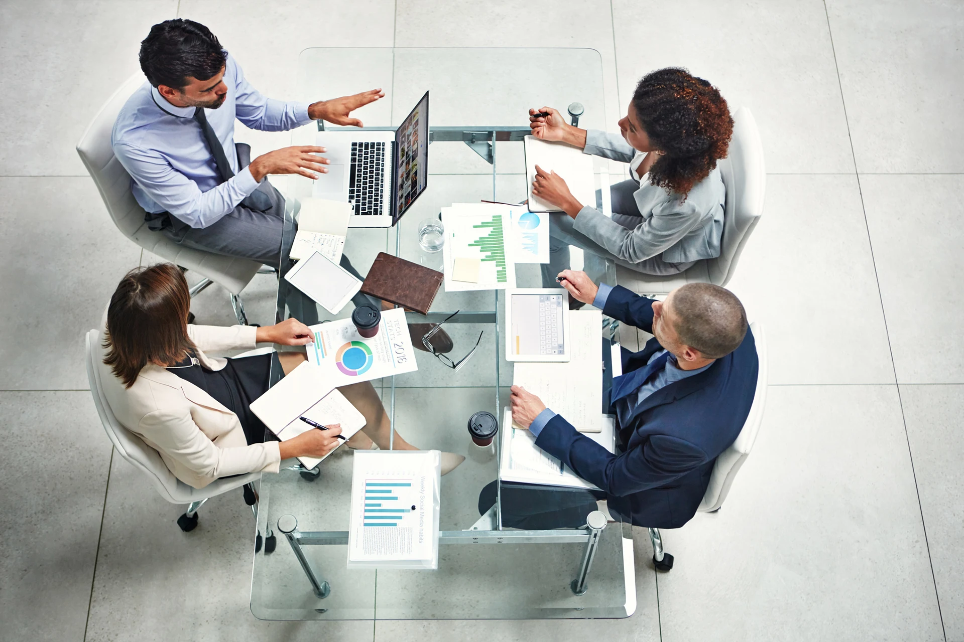 Four professionals collaborating at a meeting table, discussing strategy.
