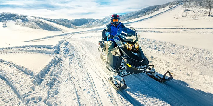 Person driving snowmobile through snowy landscape trail for Shoptalk 2018