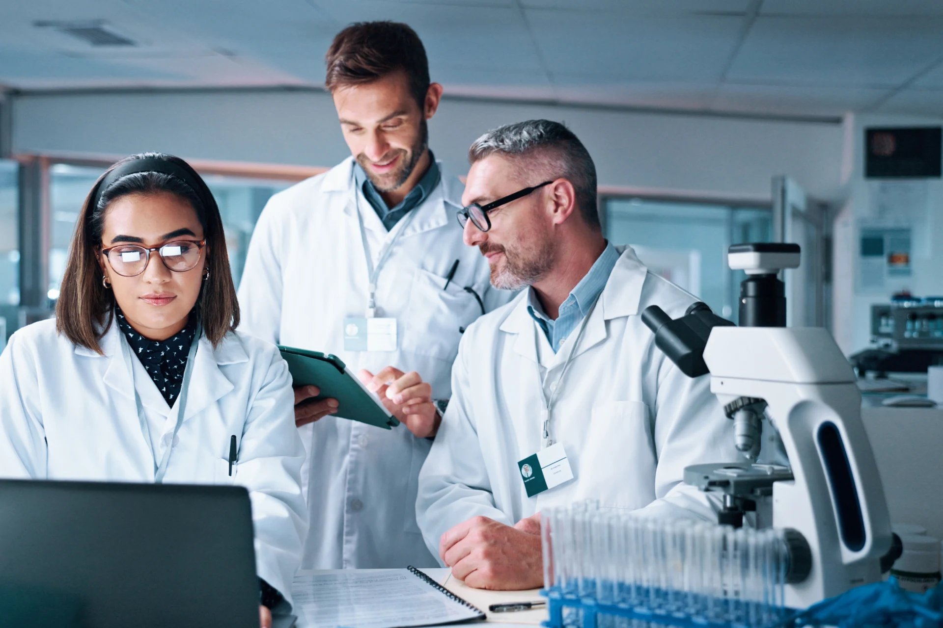 Three professionals in lab coats discussing e-commerce improvements