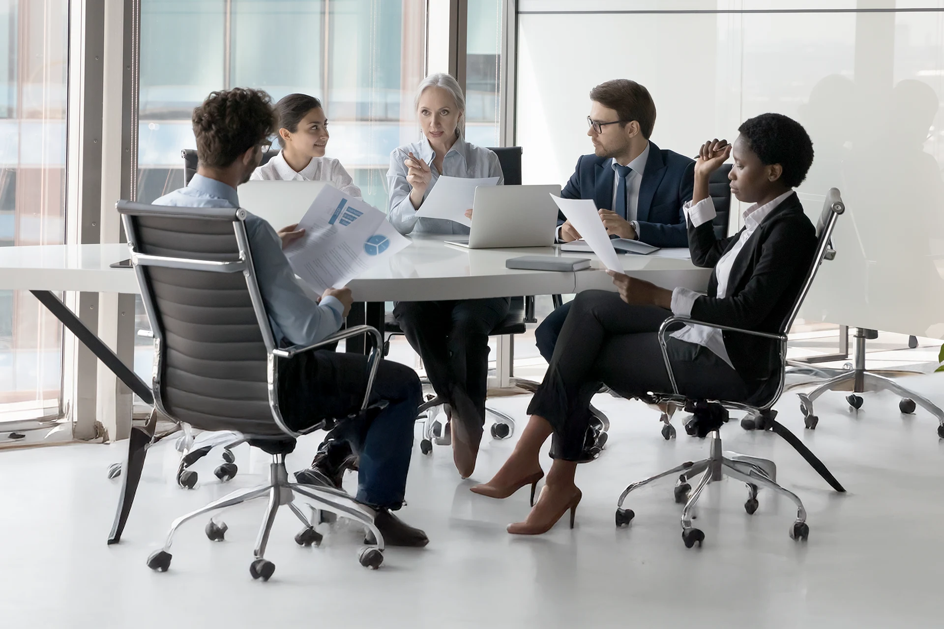 Business leaders reviewing financial reports during an investor meeting