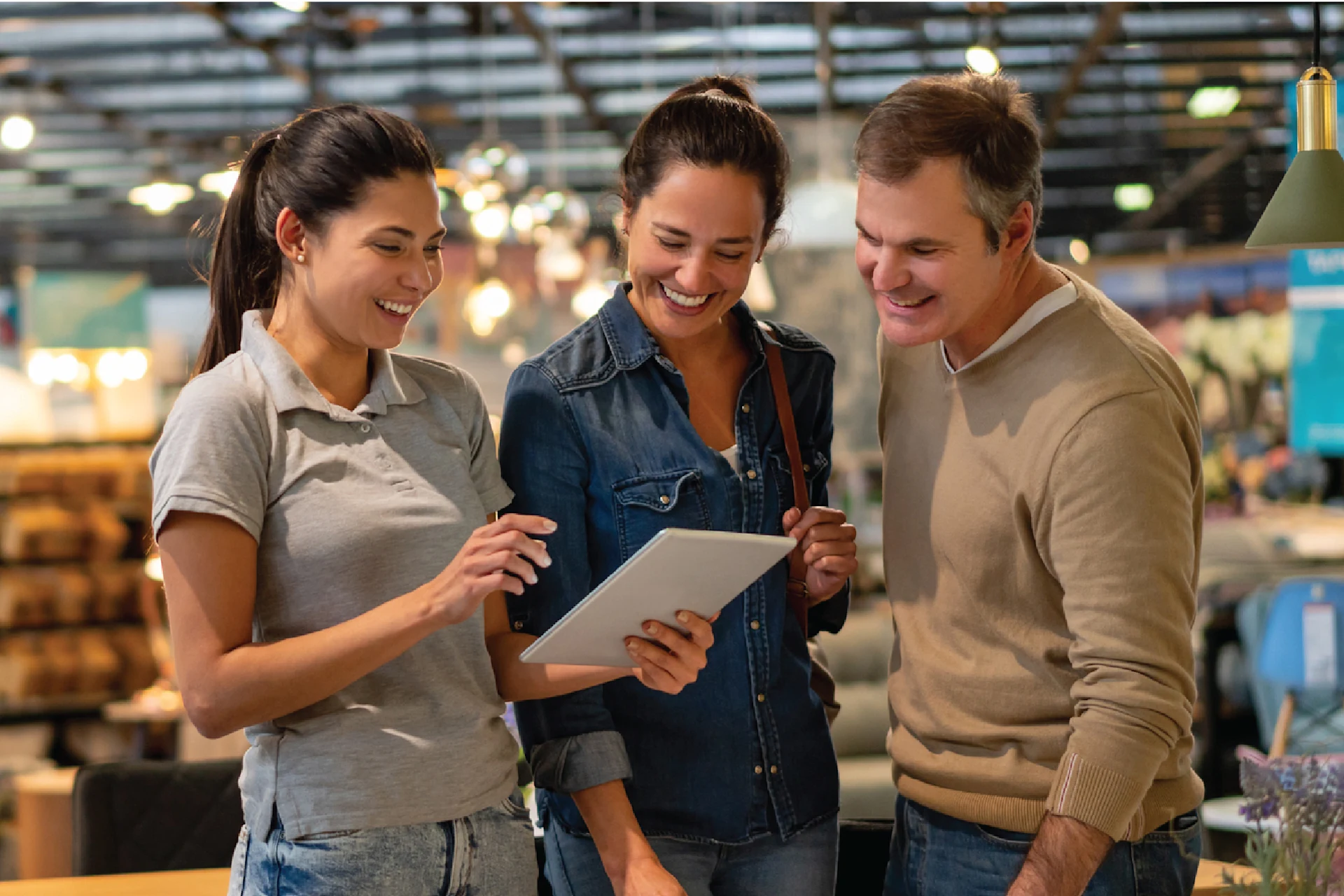 Three retail professionals analyzing store operations on tablet layout