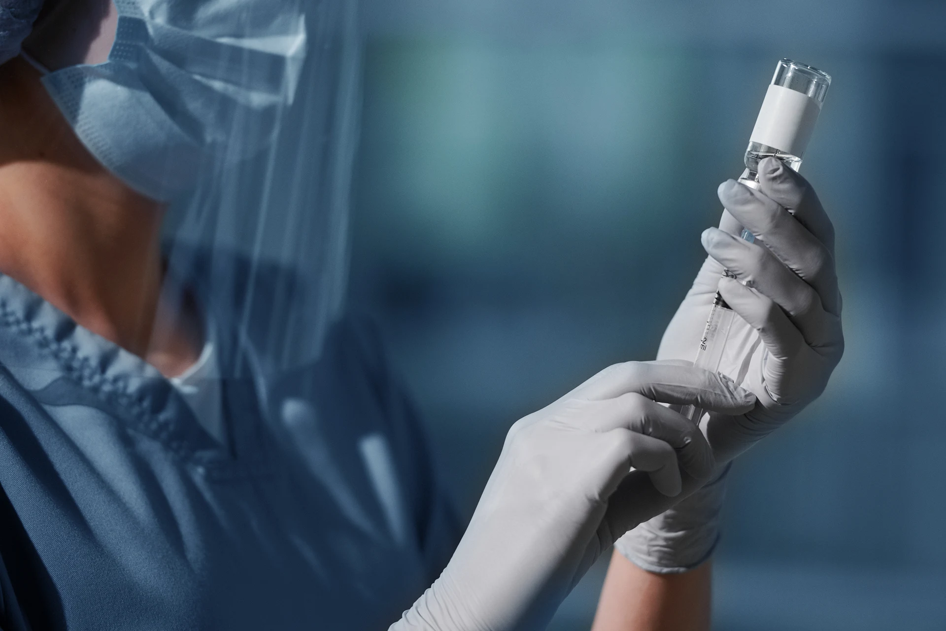 Healthcare professional preparing a syringe in a biopharma setting
