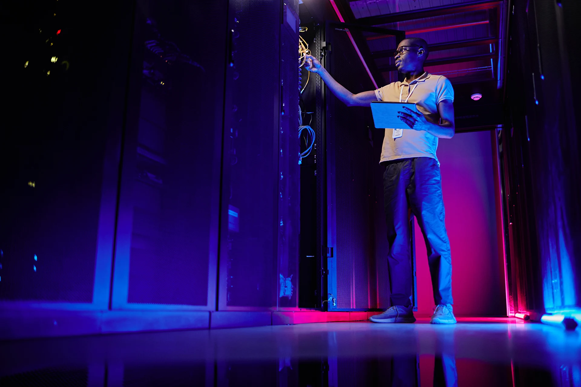 IT datacenter technician working on networking server room equipment racks