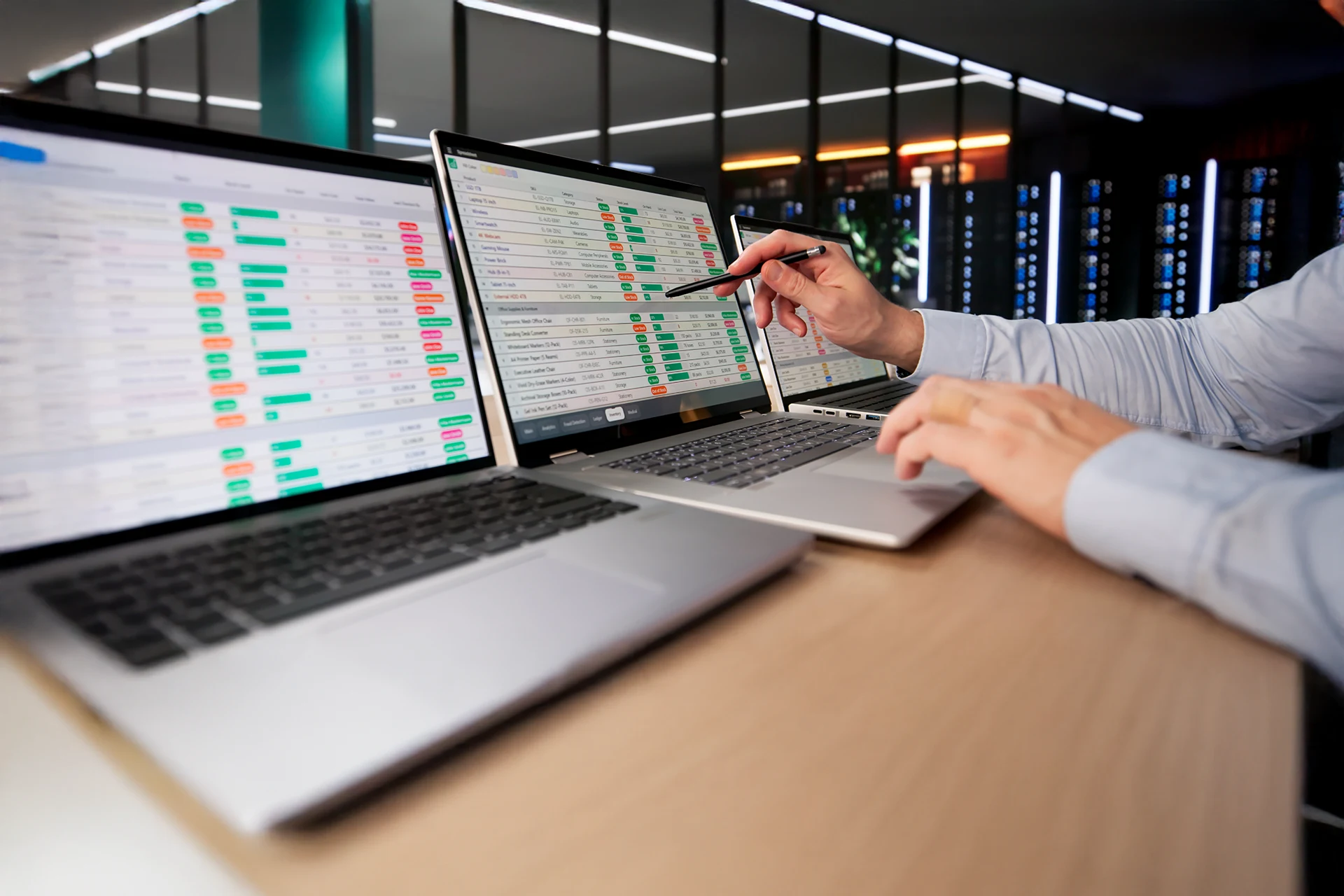 Business professional analyzing financial data on dual laptops