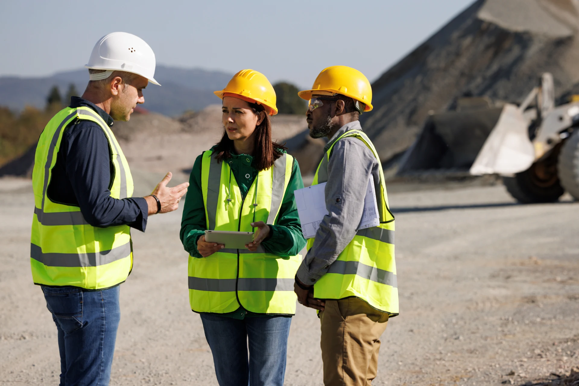Engineers in safety gear discussing M Group Services on site safety AI tech