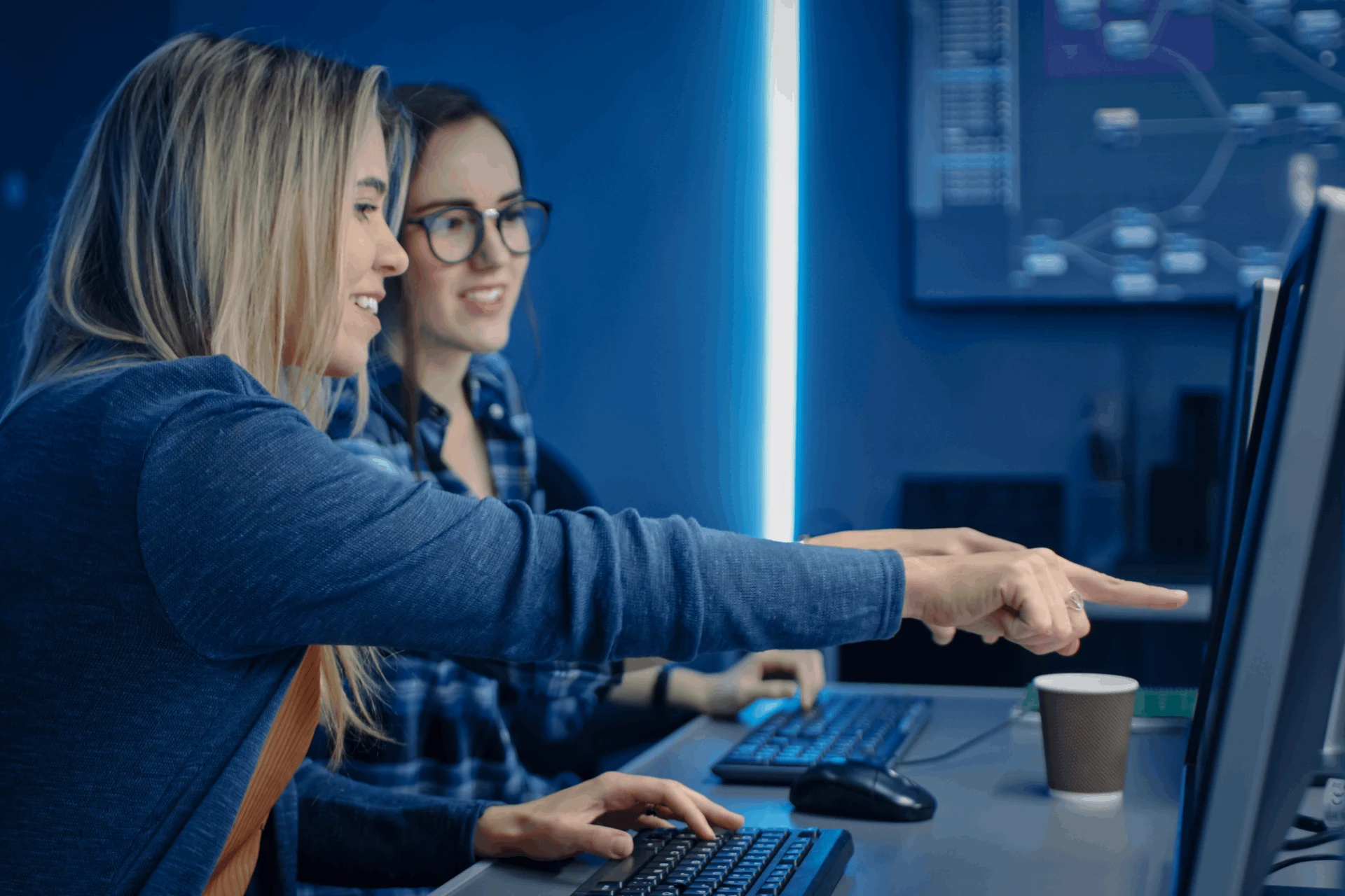 Two professionals collaborating on a computer in a modern workspace