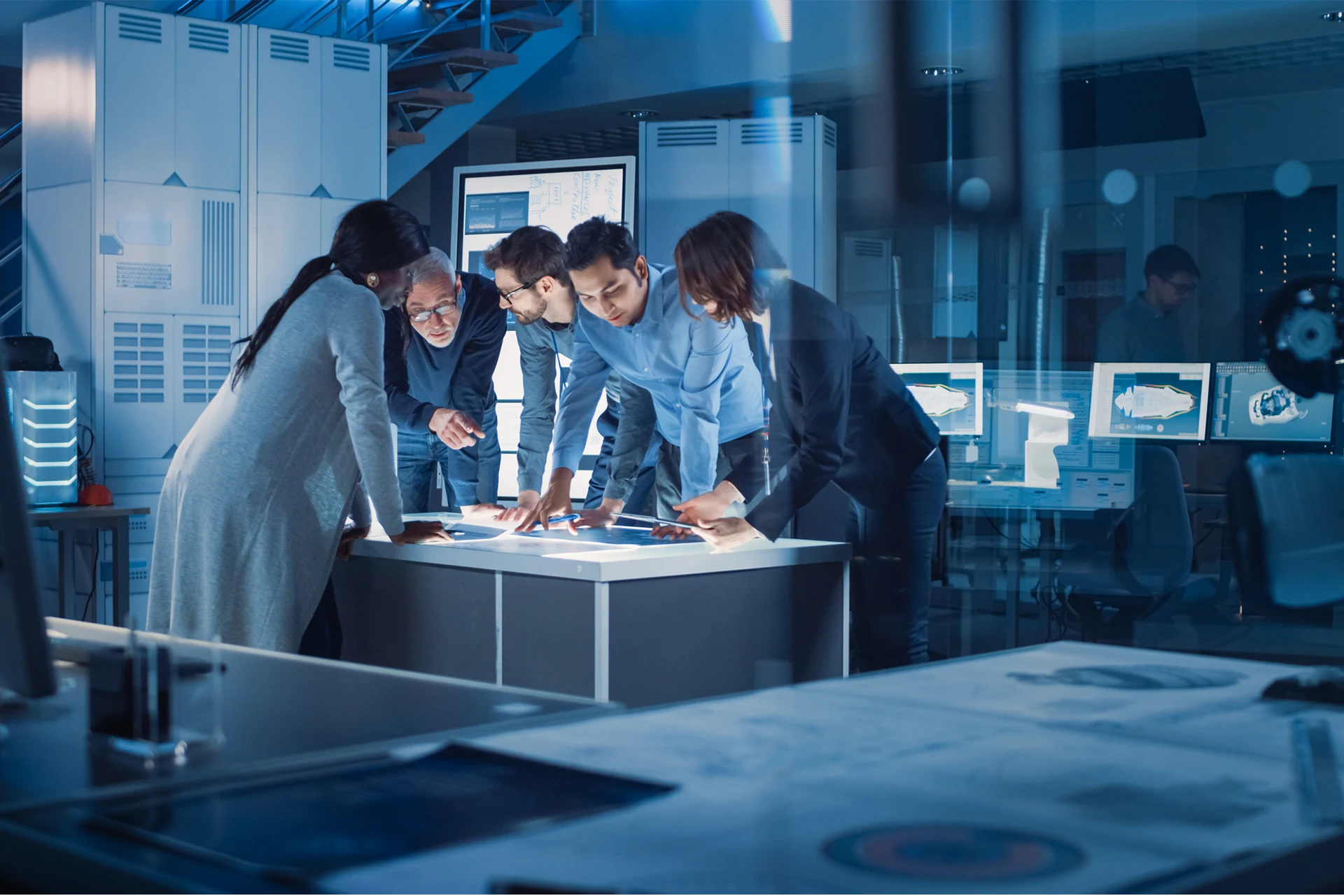 Professionals collaborating around a digital interface in an office setting.