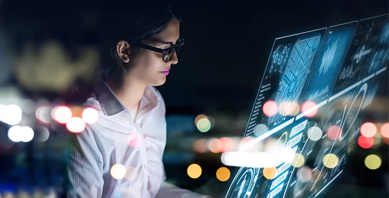 Tech professional analyzing hybrid enterprise cloud analytics screen at night
