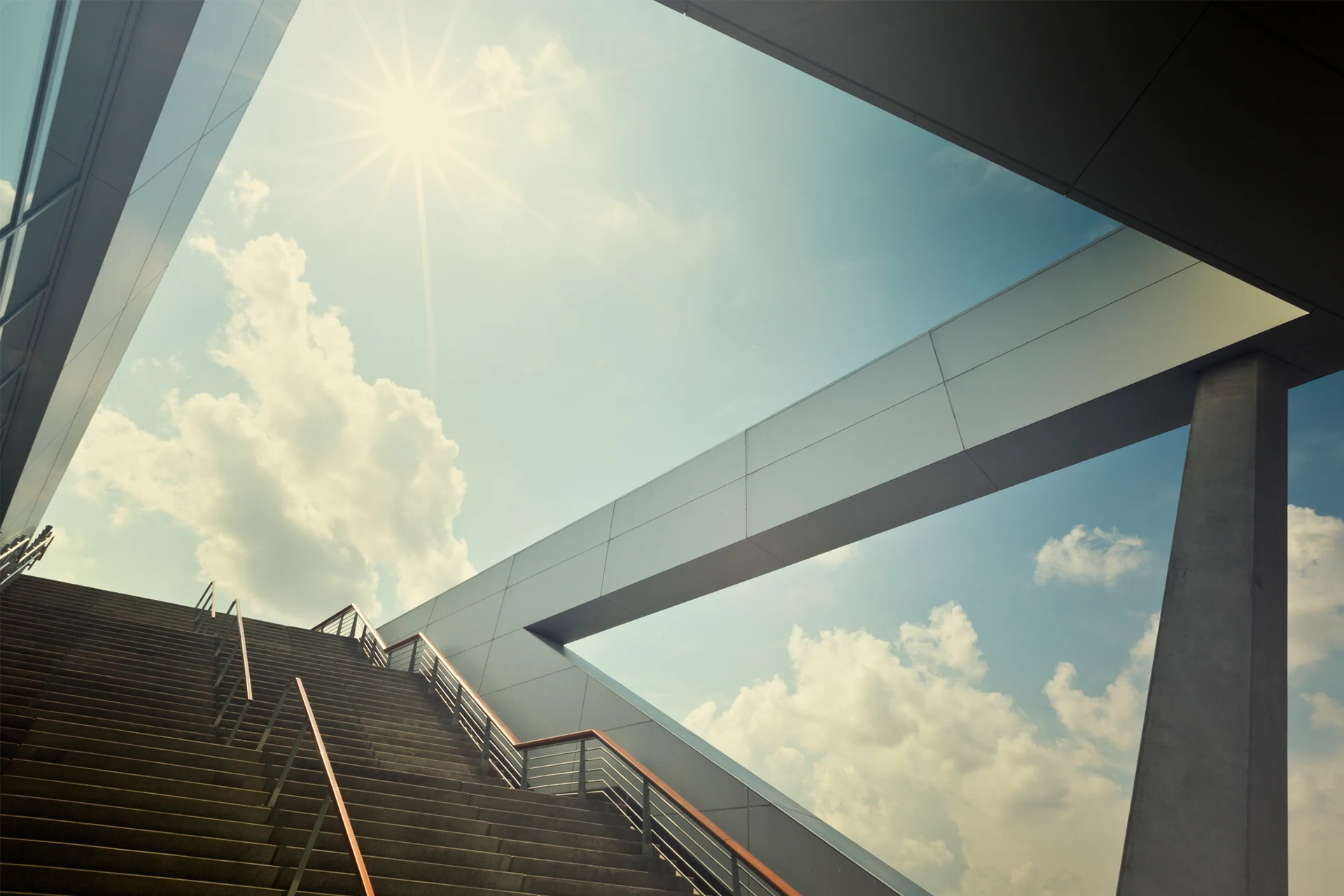 Staircase leading upwards beneath a modern architectural structure