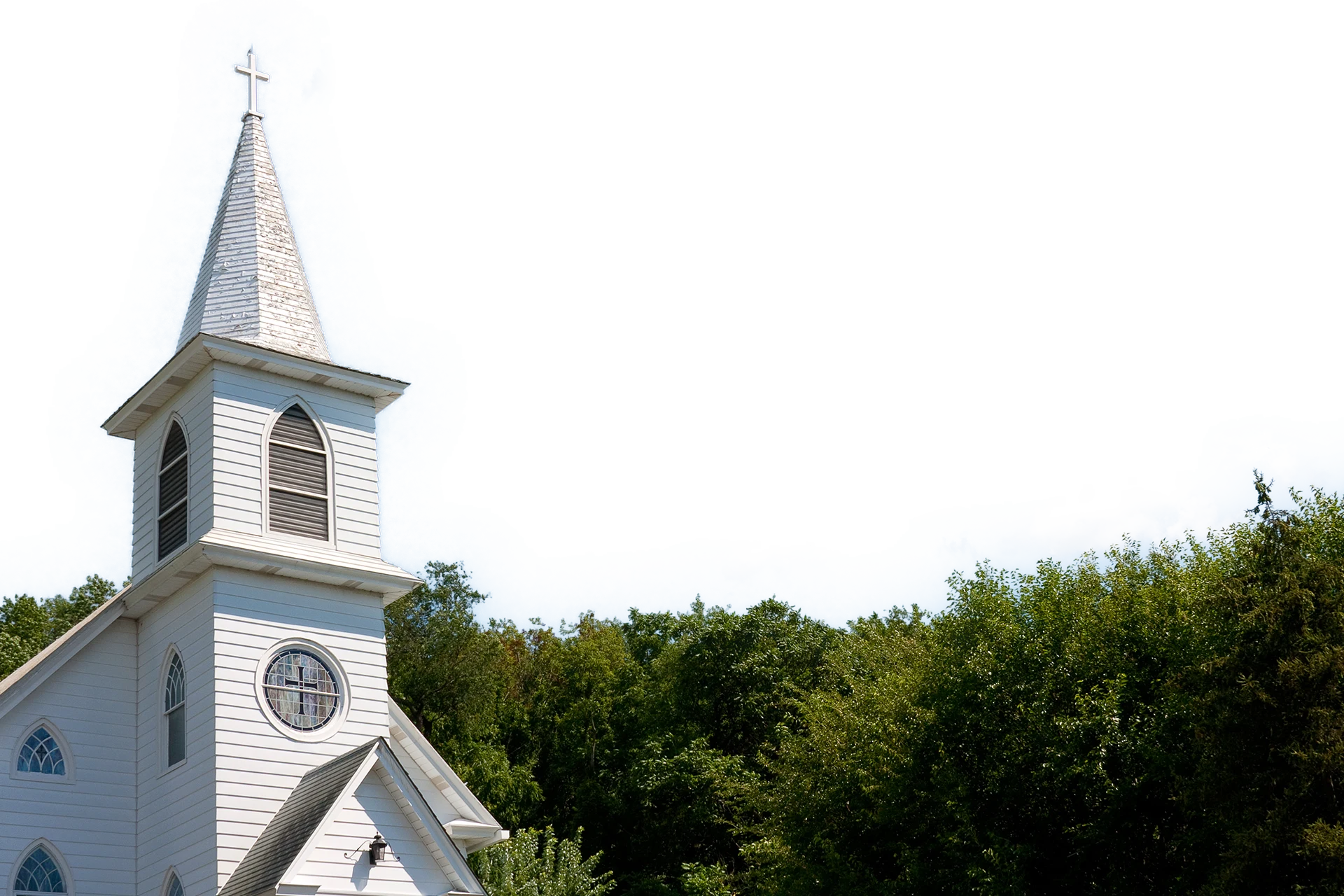 White church building with a steeple set against a blue sky.