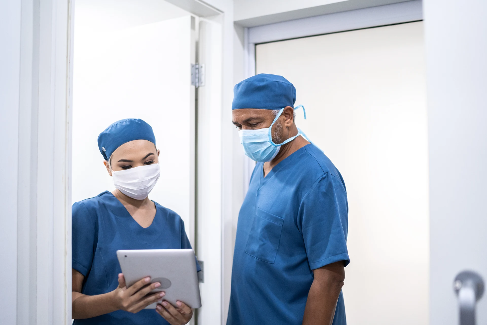 Two healthcare professionals discussing information on a tablet