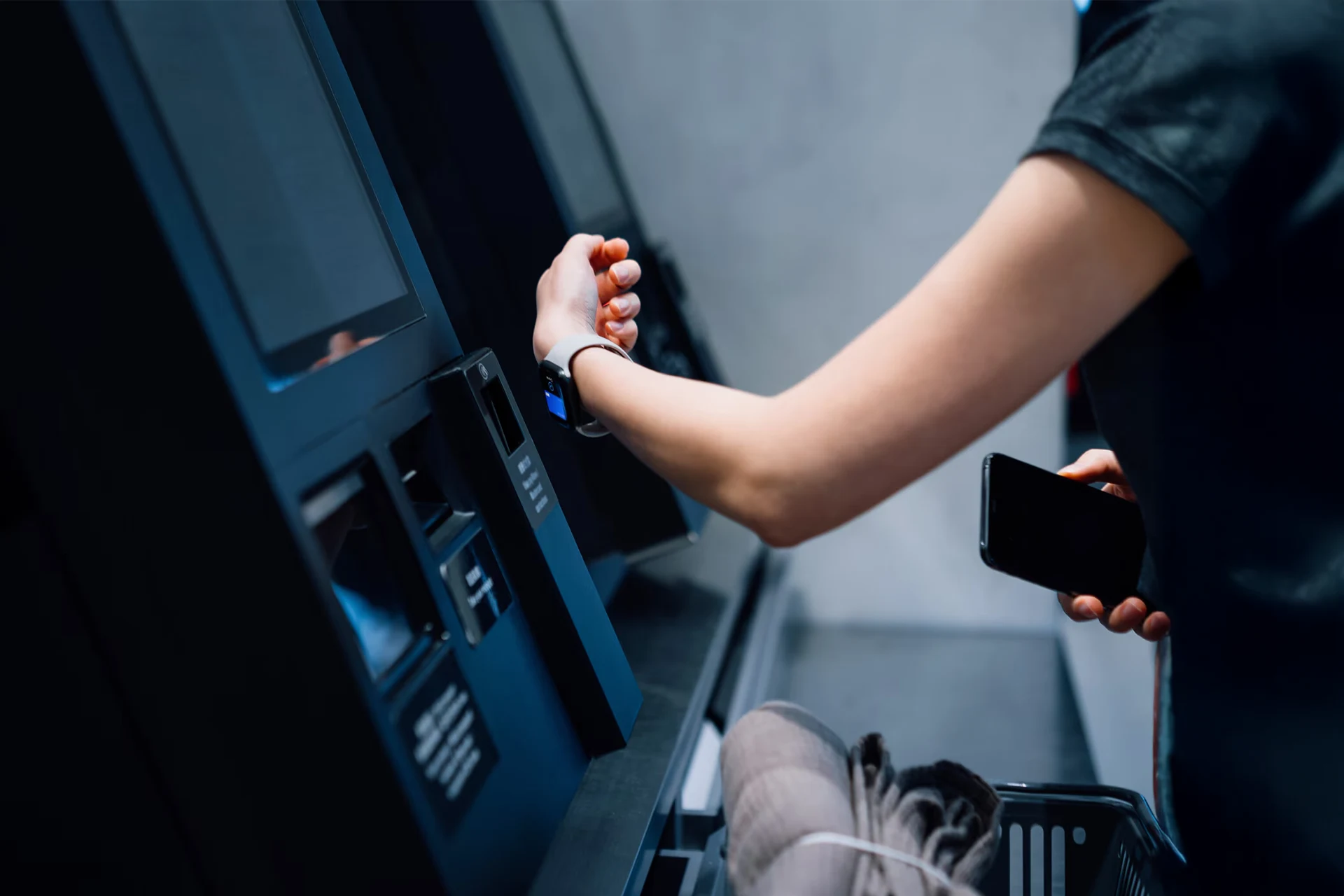 ATM transaction using smartwatch and phone, representing banking and financial services