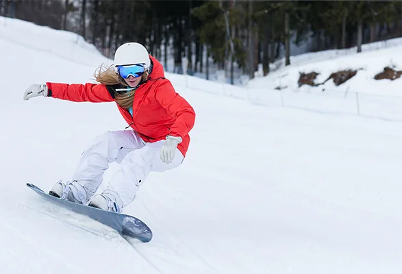 Person snowboarding down slope in orange jacket for robotic process automation