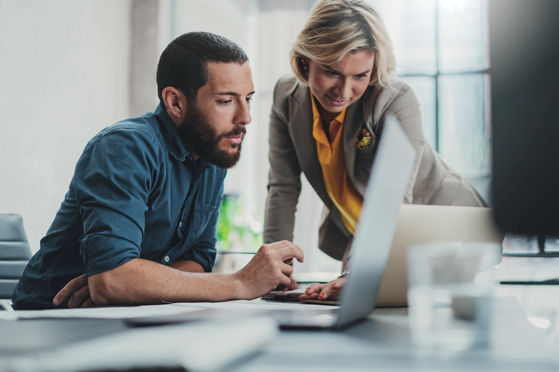 Two professionals collaborating on a project at a modern workspace