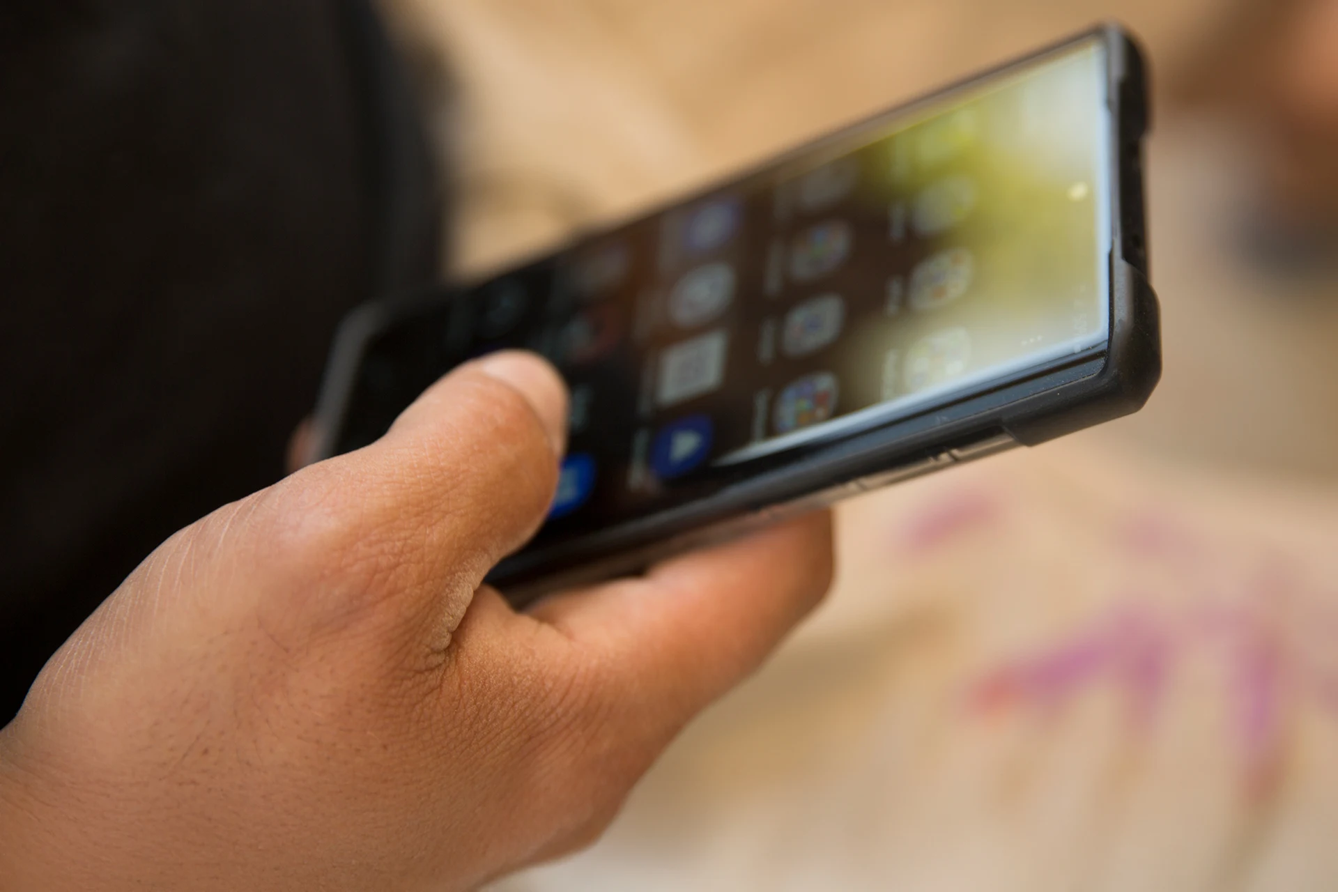 Person holding a smartphone displaying various applications.