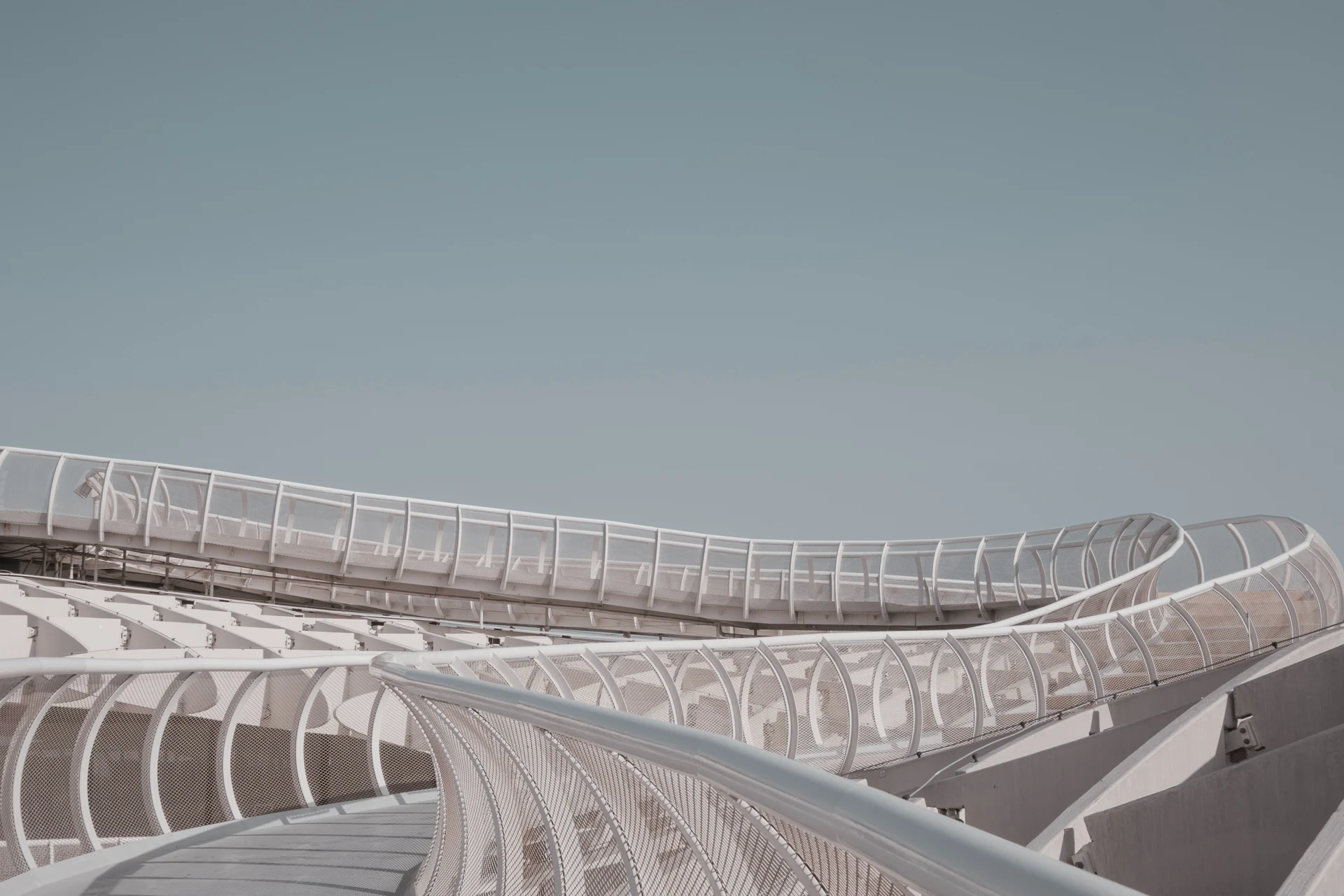 Curved walkway with glass railing in a modern architectural setting