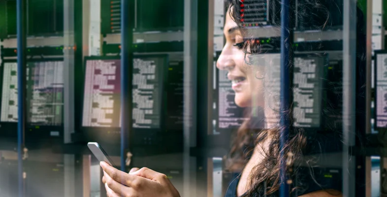 Professional using smartphone inside corporate network data center server room