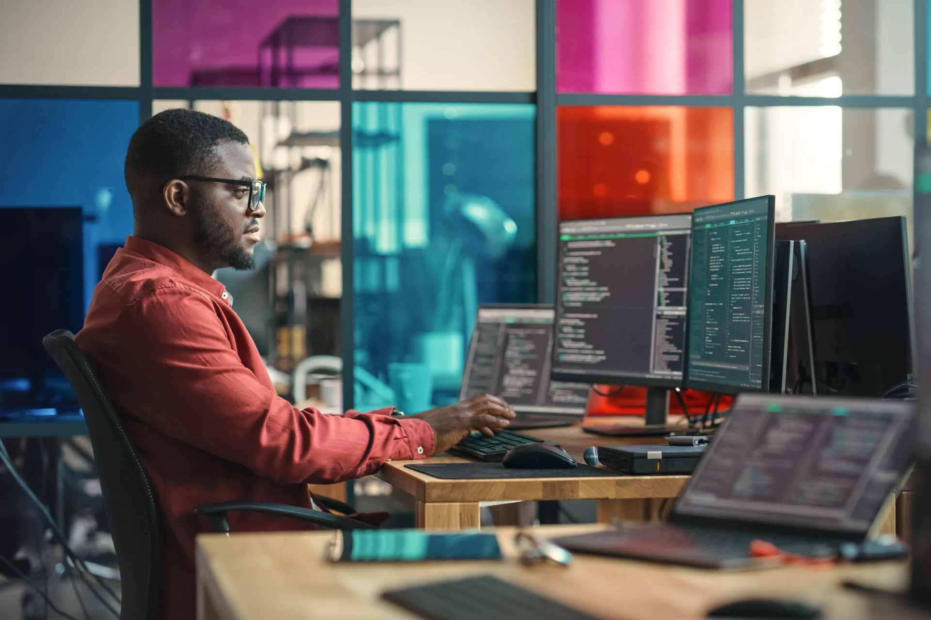 Professional working on multiple monitors in an office setting