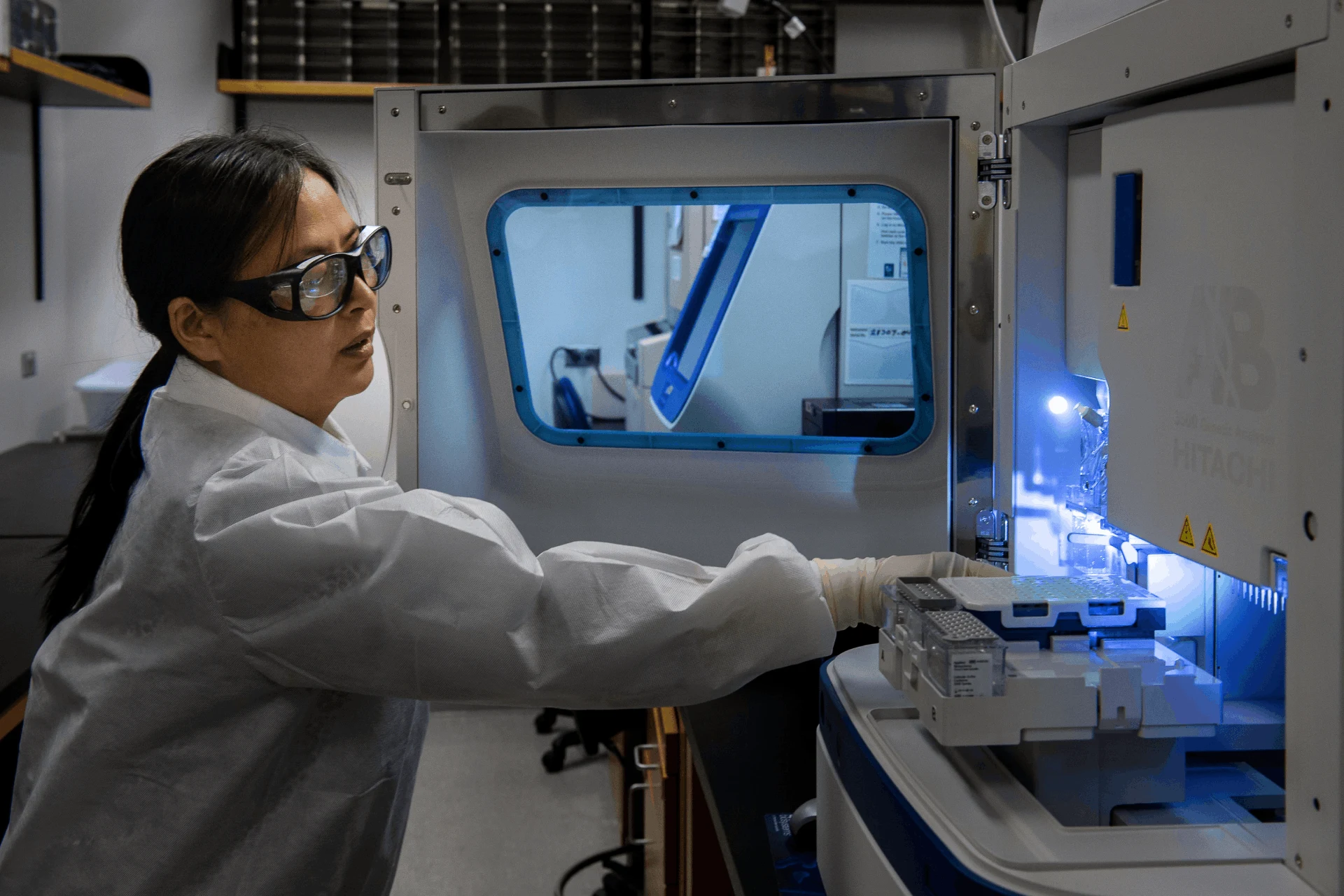 Scientist operating a lab instrument in a specialized chemical facility.