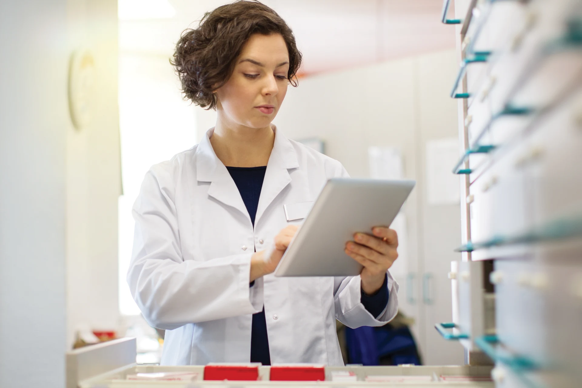 Healthcare professional using a tablet in a pharmaceutical setting