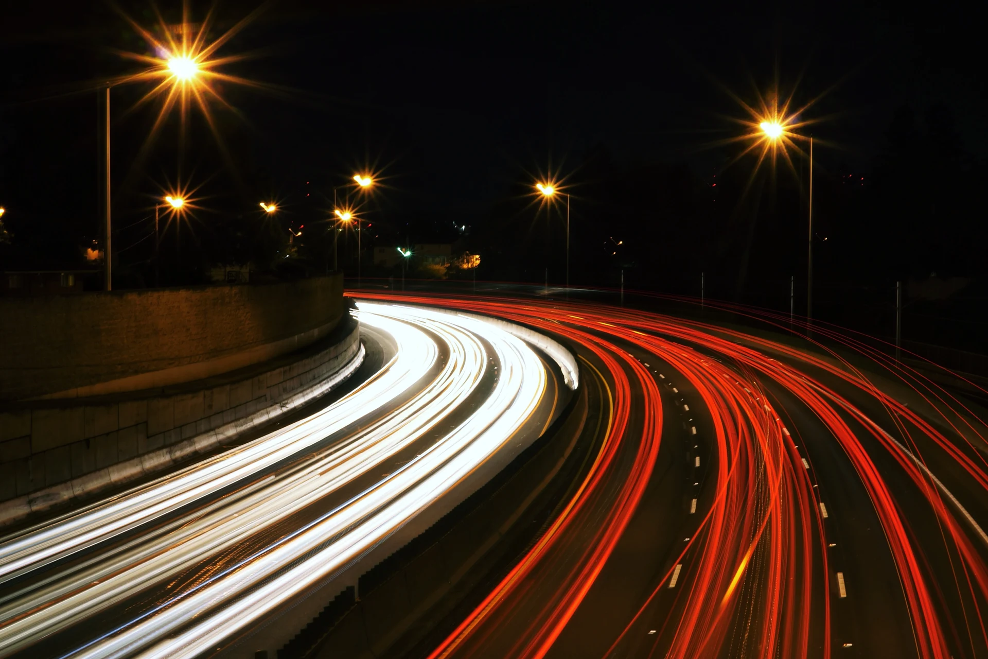 Light trails on a curving highway at night depicting speed and agility.