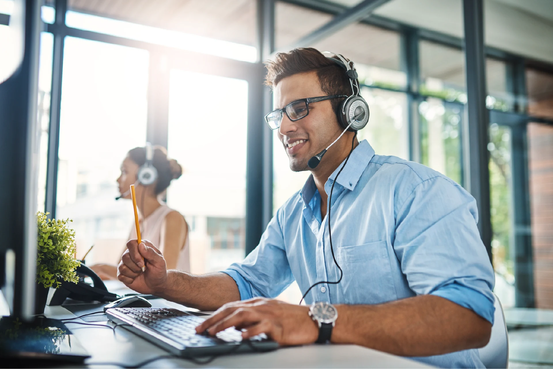 Person wearing a headset working on a computer