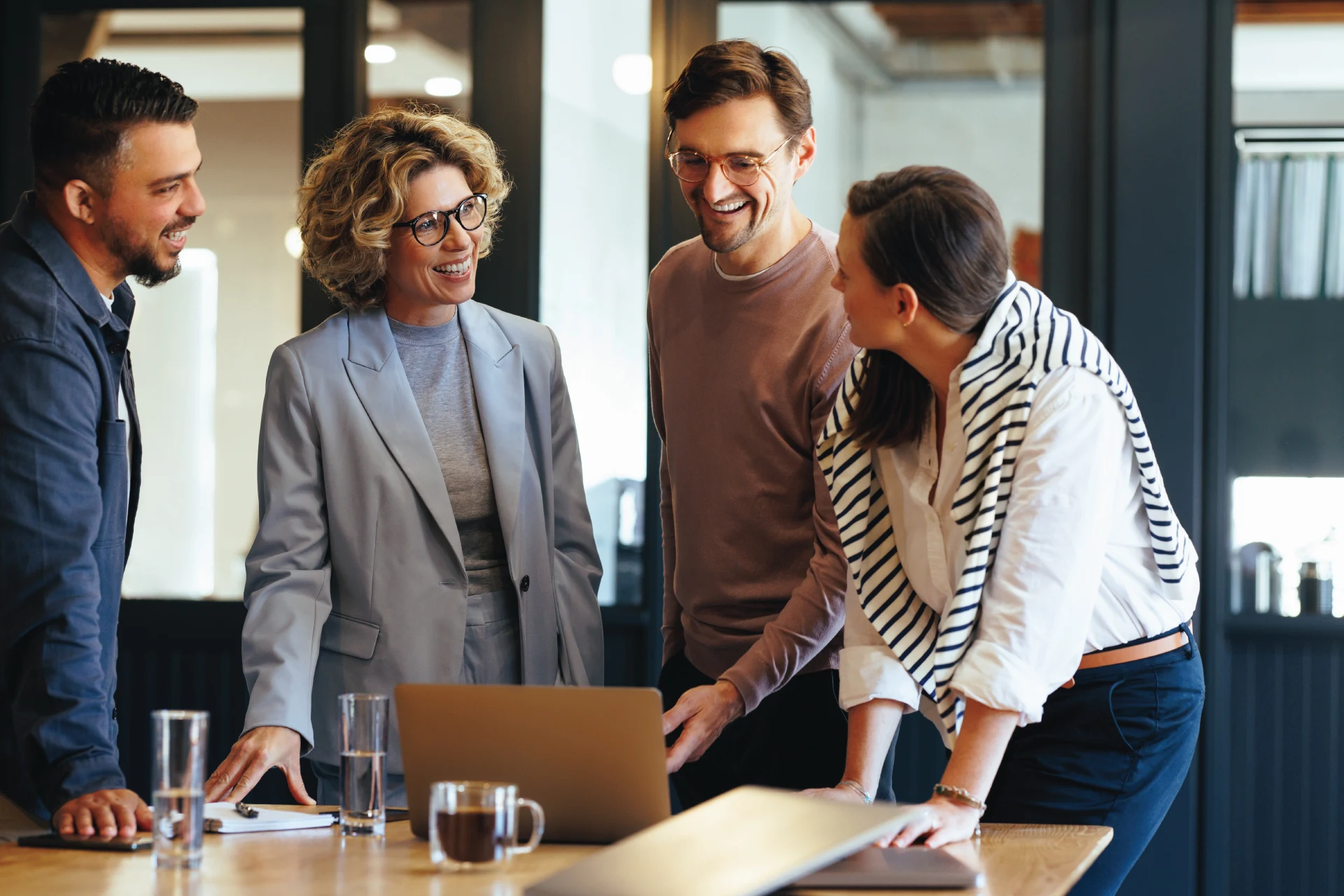 Professionals collaborating around a laptop during a business meeting.