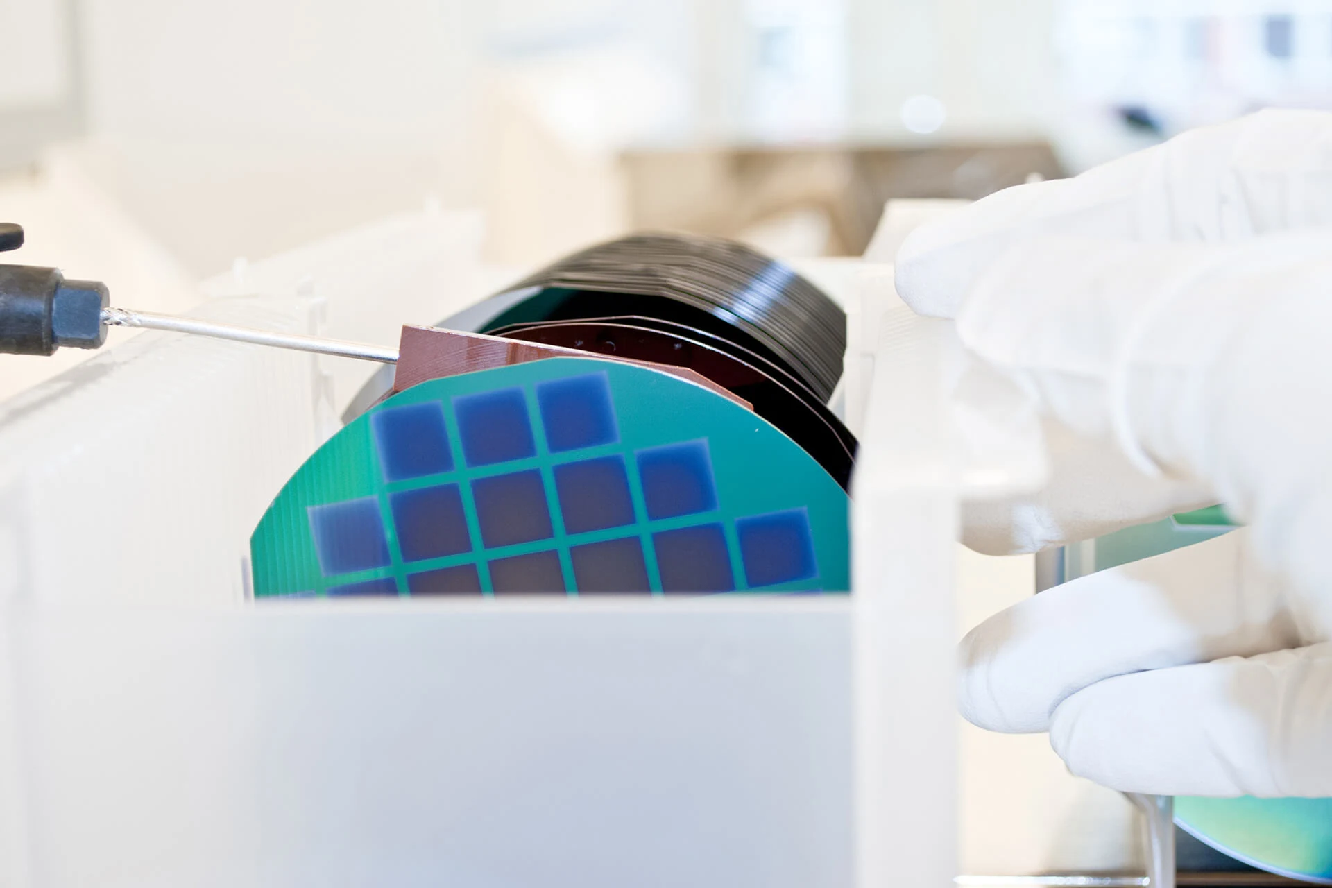 Operator handling semiconductor wafers in a cleanroom environment