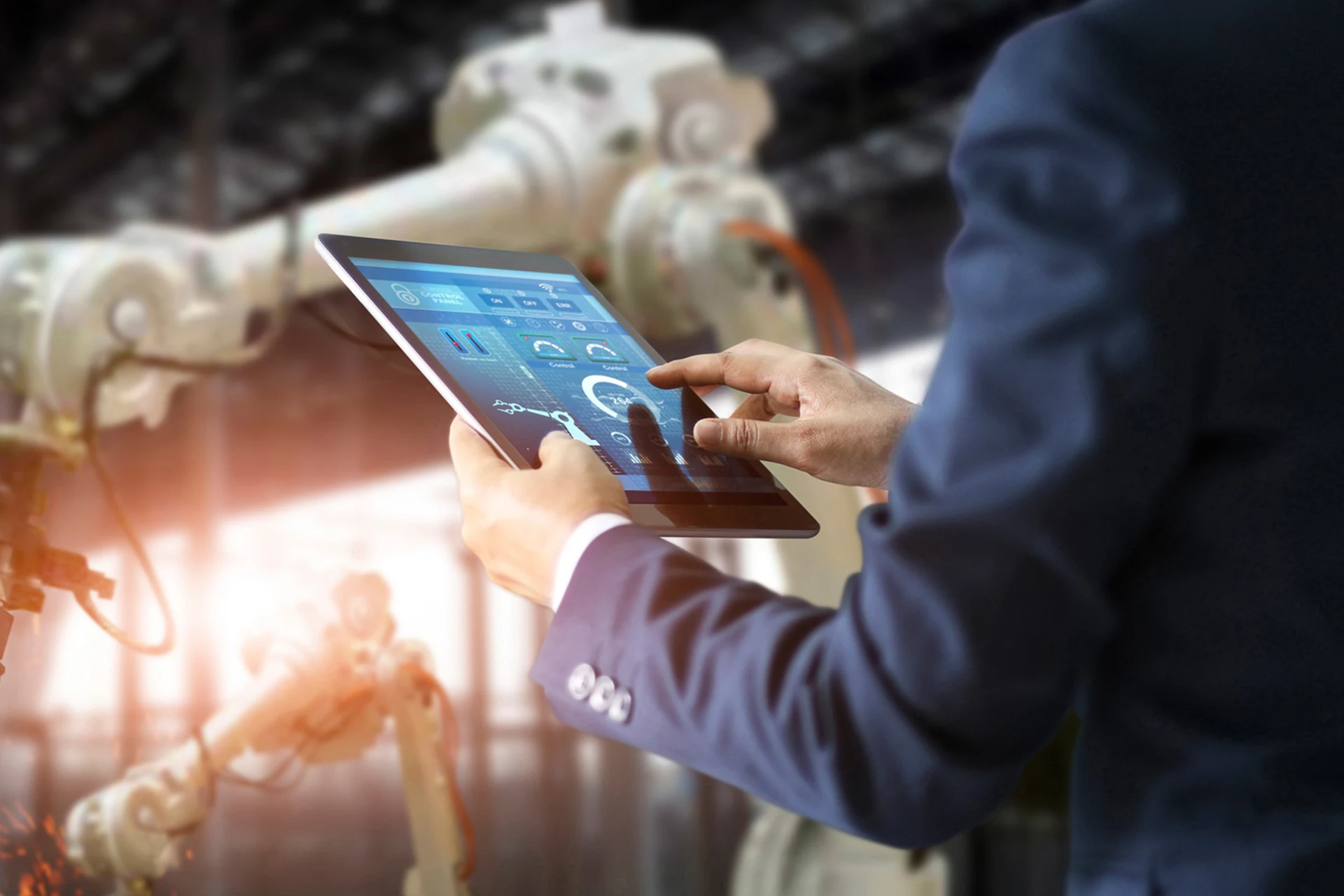 Professional using a tablet to manage automation in a manufacturing unit