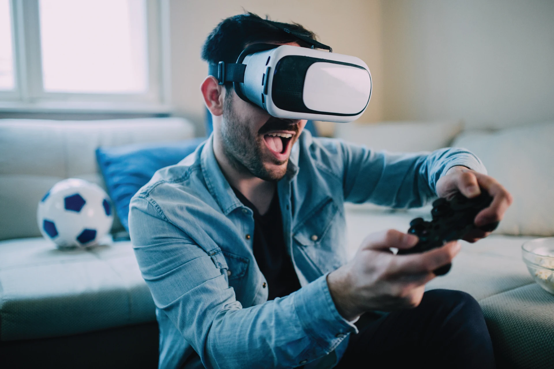 Person playing a video game with a controller and VR headset at home