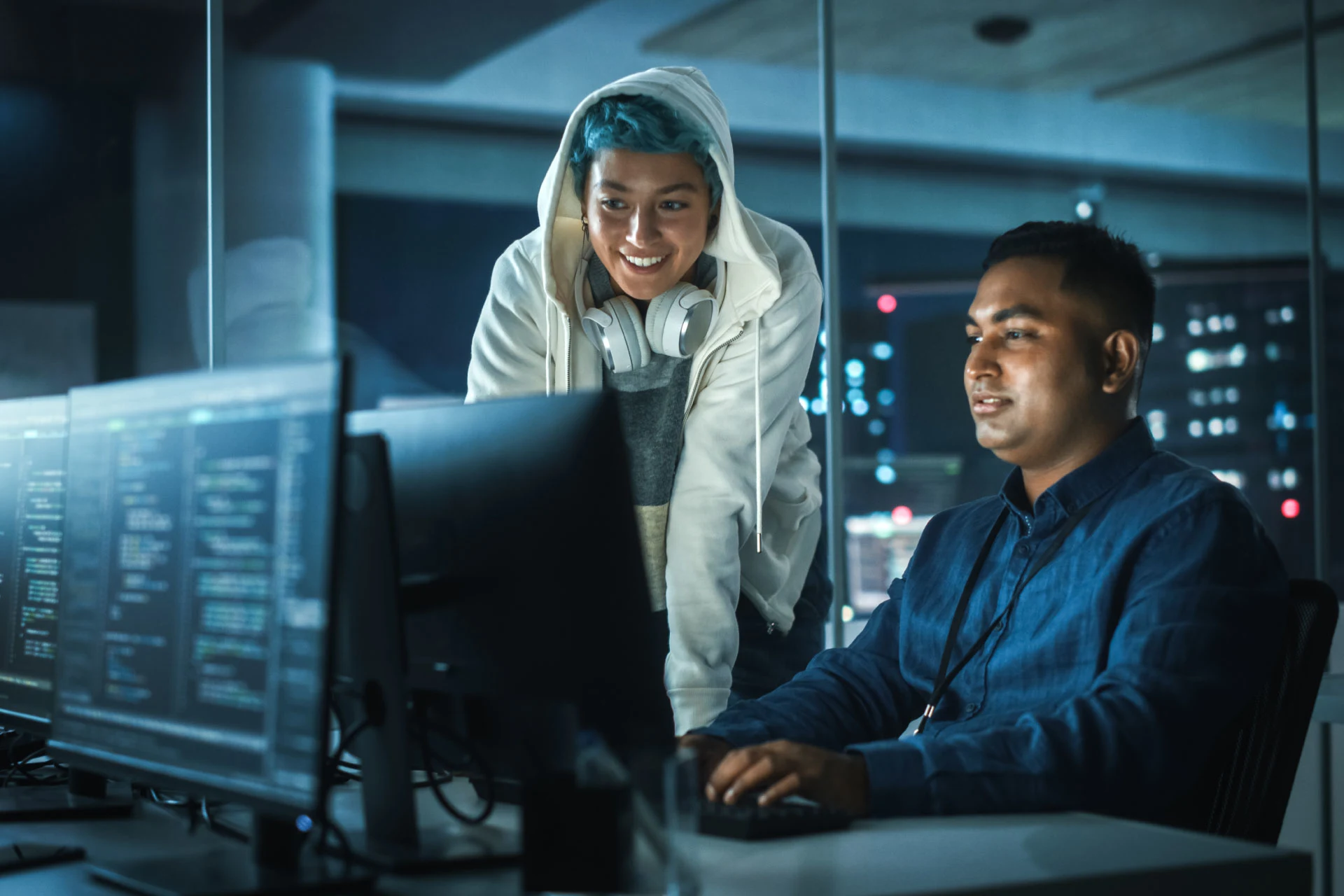 Two developers collaborating at a computer during a coding session