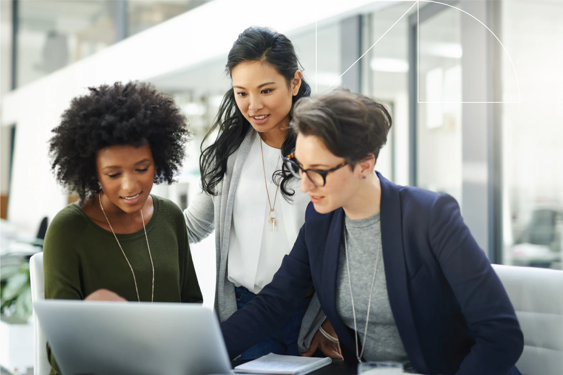 Three professionals collaborating on a laptop in a modern office